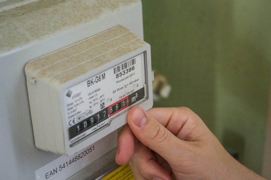 Hand bij een energiemeter die het stroomverbruik meet